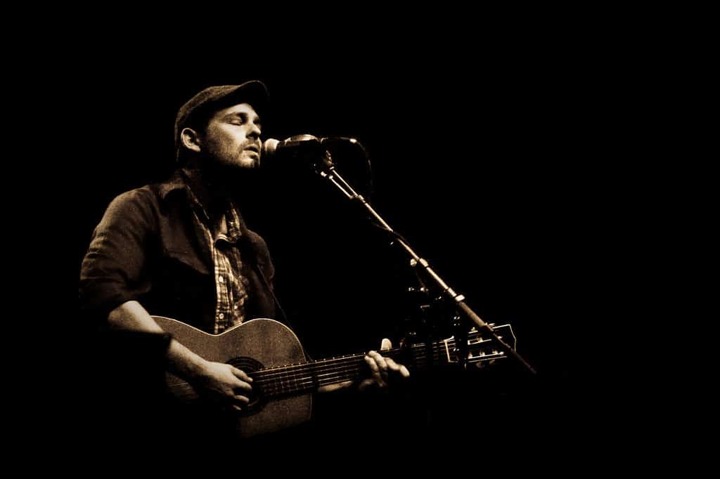 Gregory Alan Isakov playing guitar on stage